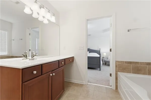 a bathroom with a tub sink and mirror
