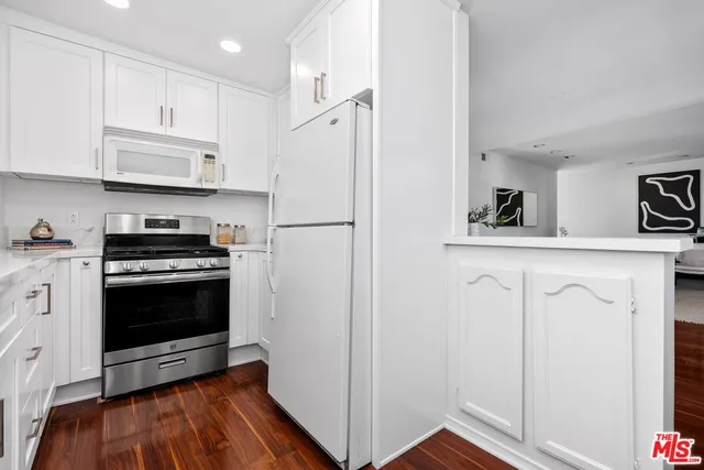 a kitchen with white cabinets and white appliances