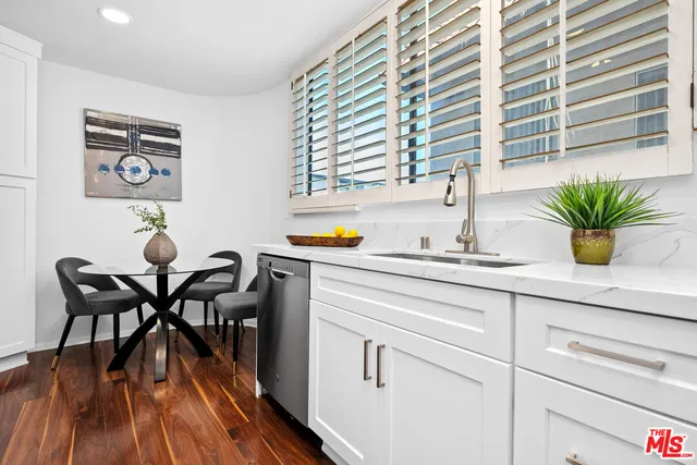 a kitchen with a table chairs and a potted plant