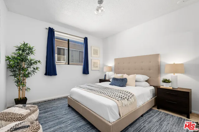 a bedroom with a bed and a potted plant