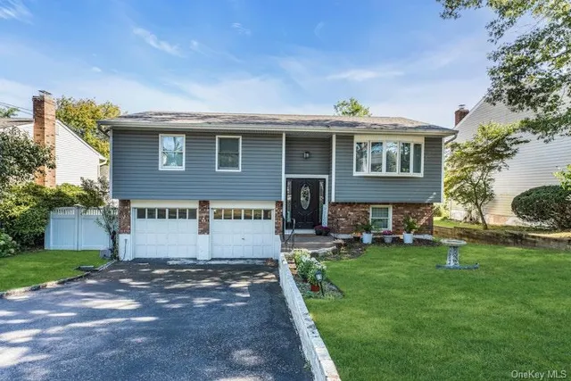a view of a house with a yard potted plants and a table