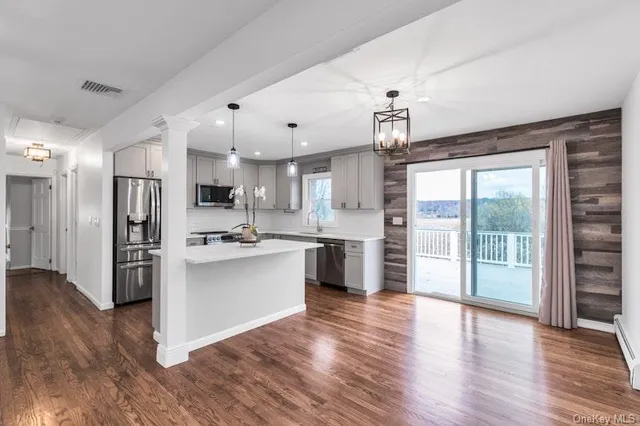 a large kitchen with stainless steel appliances granite countertop a refrigerator a stove a sink dishwasher a oven with wooden floor