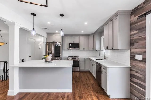 a large kitchen with stainless steel appliances kitchen island granite countertop a sink and cabinets