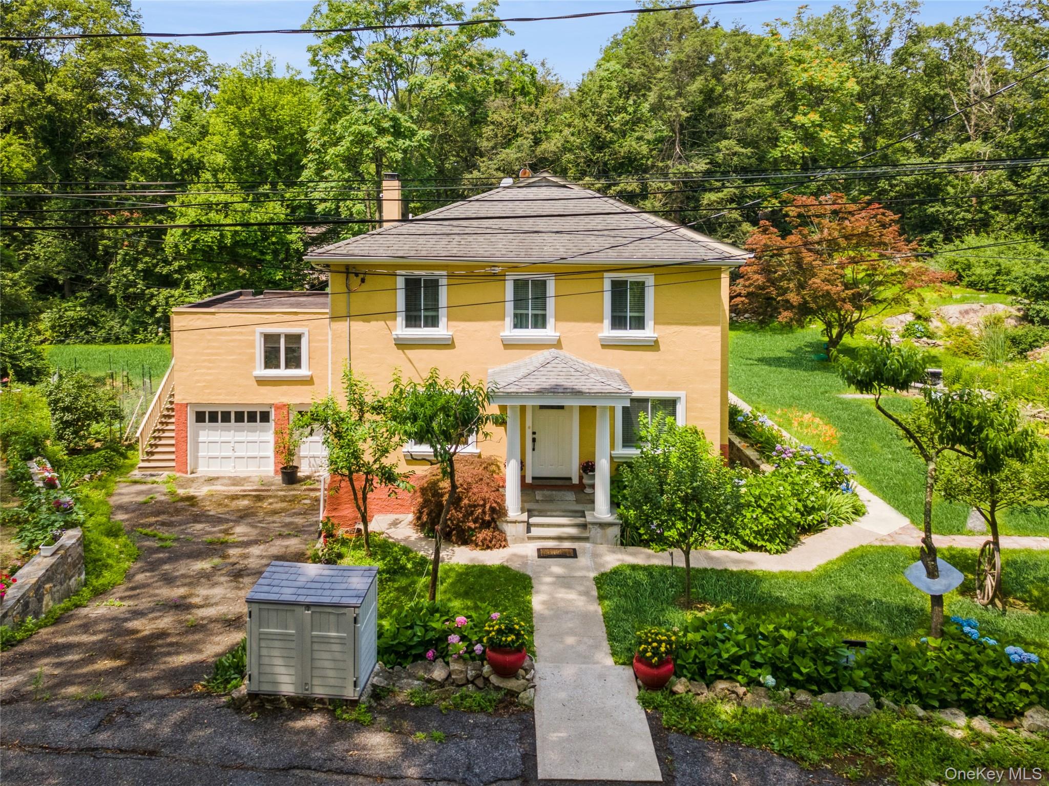 a front view of a house with a yard and trees