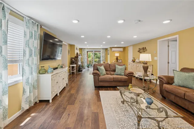 a living room with furniture flat screen tv and a large window