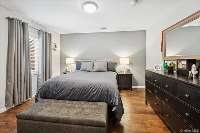 a bedroom with a large bed and a flat tv screen on a dresser
