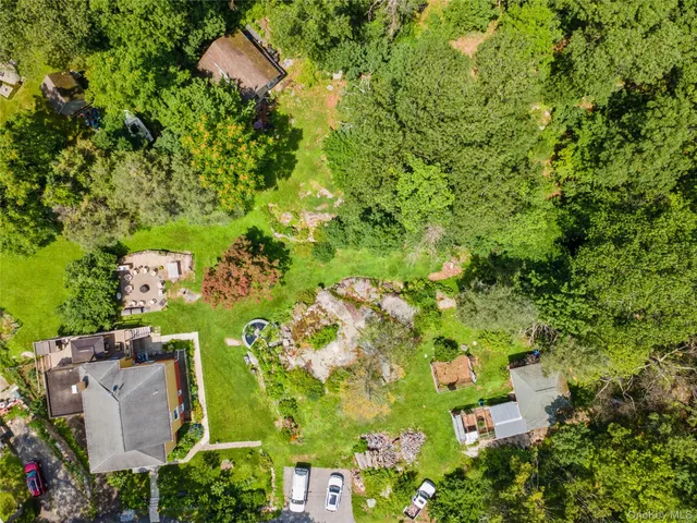 an aerial view of residential house with outdoor space and trees all around