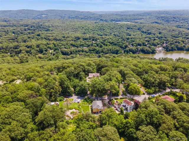 an aerial view of residential house with outdoor space and trees all around