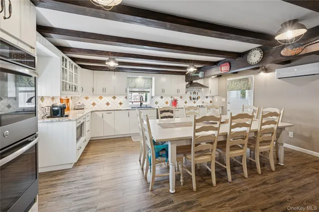 a kitchen with stainless steel appliances kitchen island granite countertop a table and chairs in it