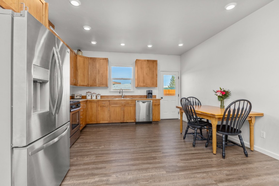 984 Dry Creek Road Hayden, CO 81639 - Photo 7 of 30 a kitchen with stainless steel appliances kitchen island granite countertop a dining table chairs and a refrigerator
