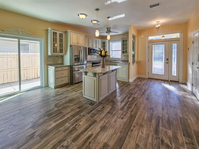 a kitchen with stainless steel appliances granite countertop a stove a sink and a microwave