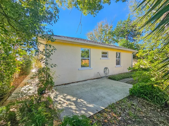 a view of a big room with wooden floor and a kitchen view