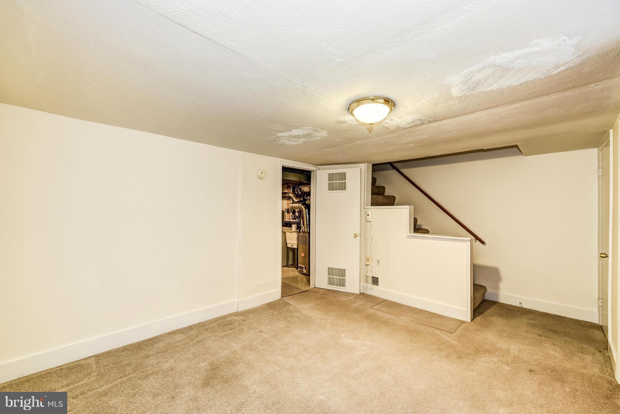 12036 Claridge Road Silver Spring, MD 20902 - Photo 22 of 27 an empty room with stairs and white walls