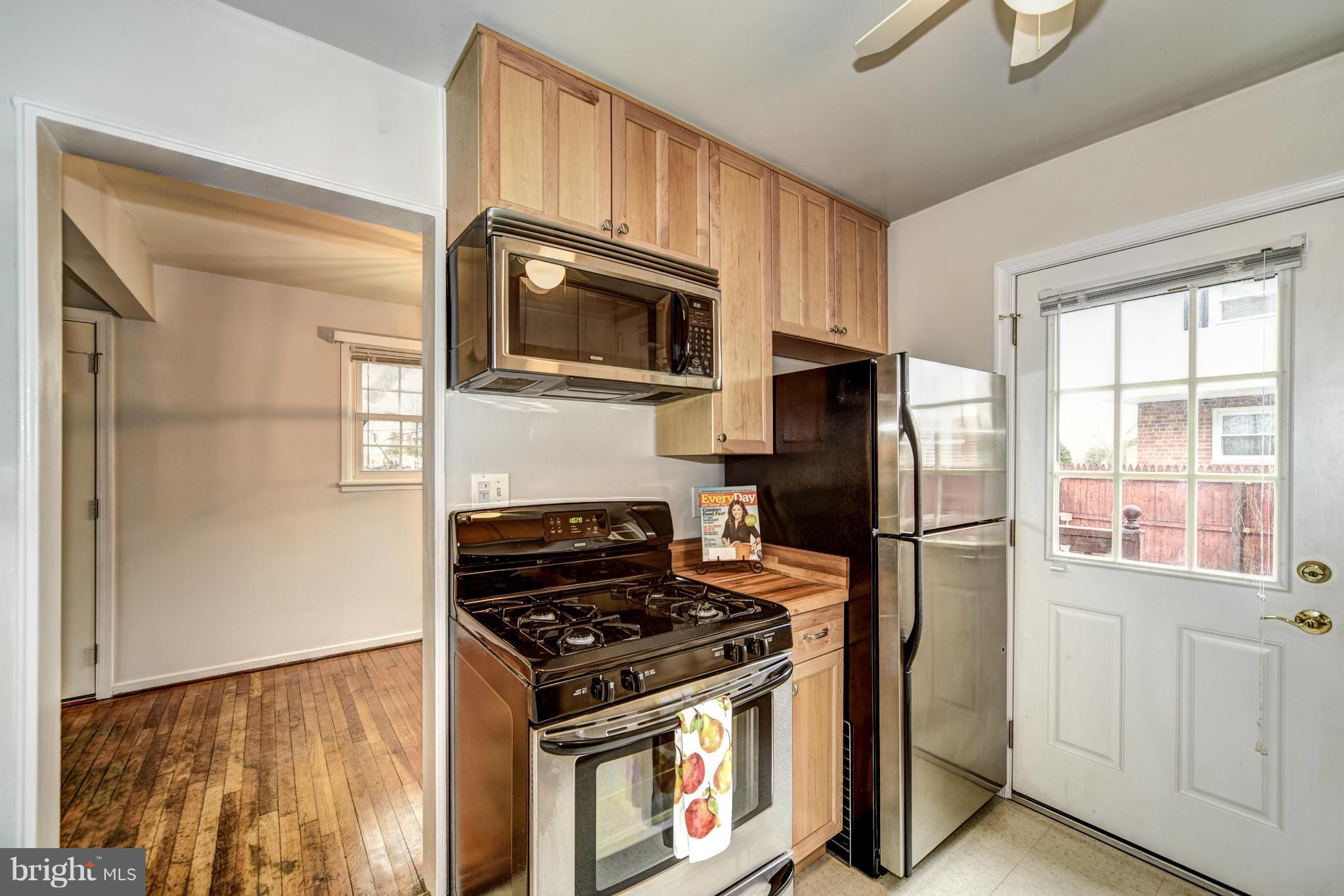 12036 Claridge Road Silver Spring, MD 20902 - Photo 10 of 27 a kitchen with stainless steel appliances granite countertop a stove a refrigerator and a microwave