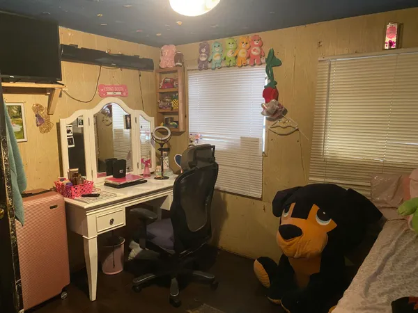 a bedroom with a bed and a refrigerator