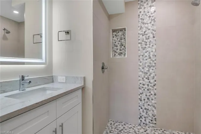 a bathroom with a sink a vanity and a shower