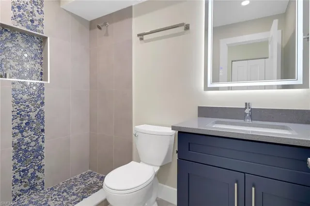 a bathroom with a granite countertop sink toilet and shower
