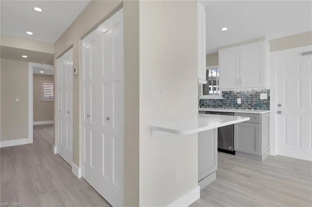 a kitchen with kitchen island granite countertop a sink cabinets and wooden floor
