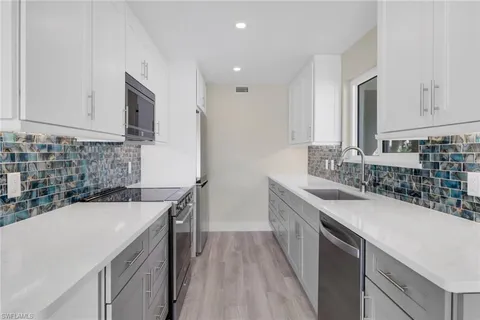 a kitchen with a sink stove and cabinets