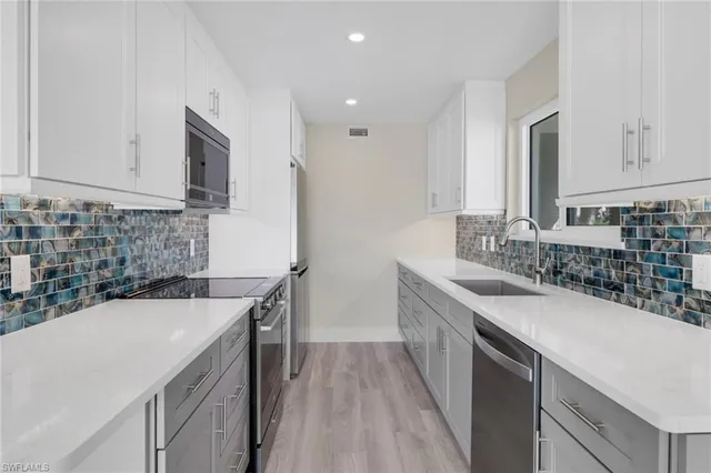 a kitchen with a sink stove and cabinets