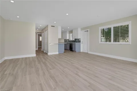 a large kitchen with stainless steel appliances granite countertop a large counter top and a wooden floor