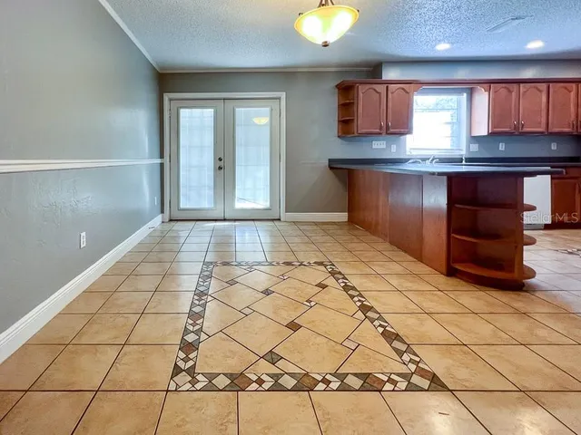 a view of a kitchen with kitchen island a large counter top stainless steel appliances and cabinets