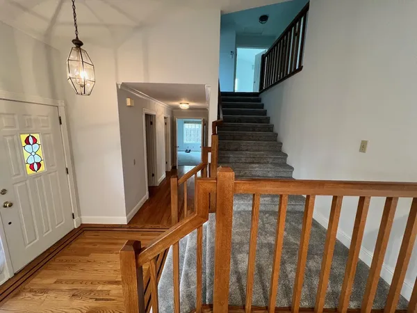 a view of staircase with railing and a chandelier