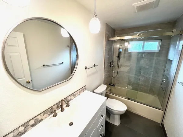 a bathroom with a sink a toilet and shower