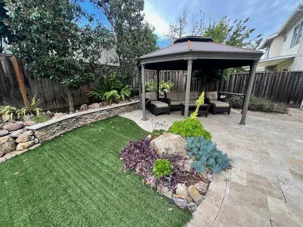 a view of a chair and table in backyard of the house