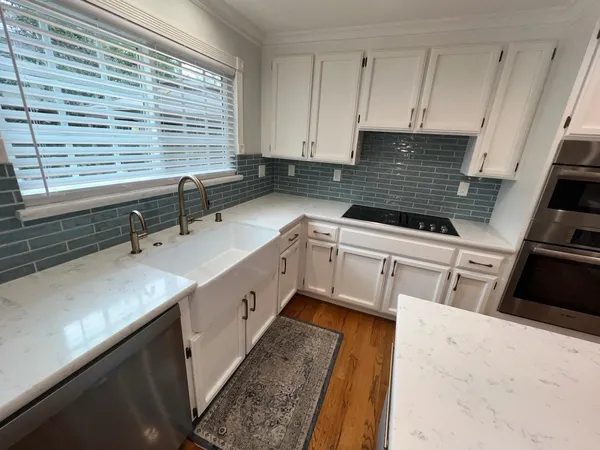 a kitchen with a sink a stove and cabinets