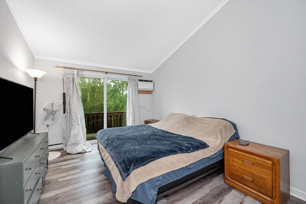 22 River Street, Unit 13 Hudson, MA 01749 - Photo 12 of 23 a bedroom with a bed and a flat tv screen on the dresser