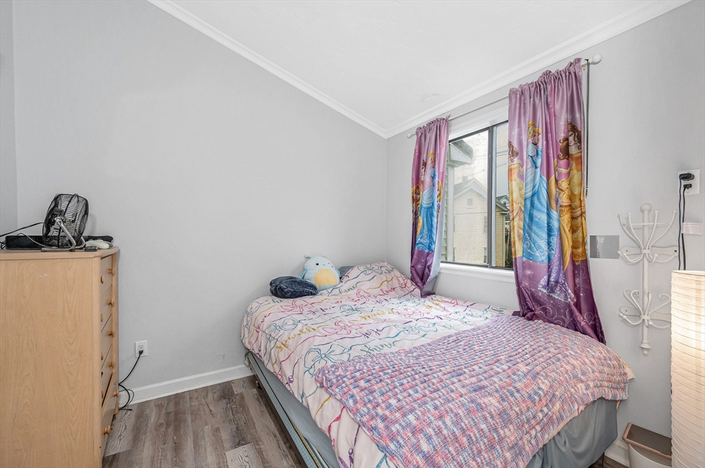 22 River Street, Unit 13 Hudson, MA 01749 - Photo 19 of 23 a bedroom with a bed and wooden floor