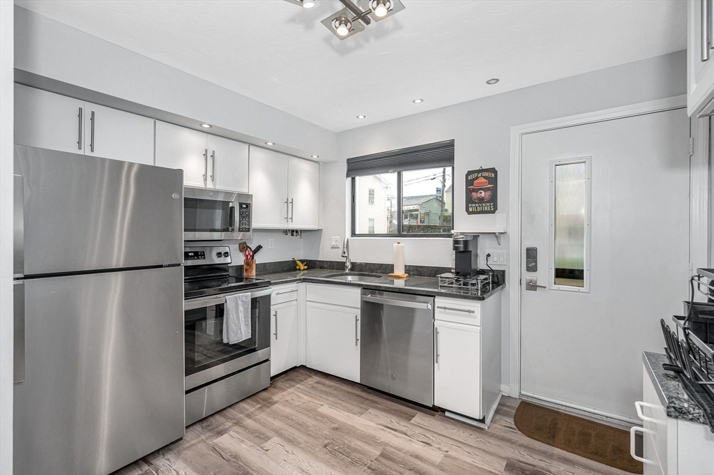 22 River Street, Unit 13 Hudson, MA 01749 - Photo 3 of 23 a kitchen with white cabinets and white appliances