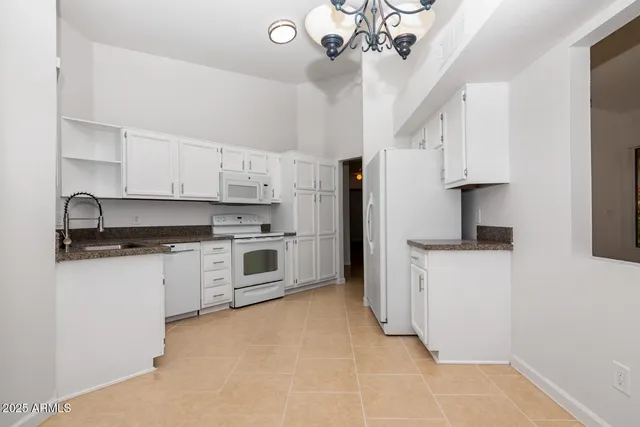 a kitchen with white cabinets and white appliances