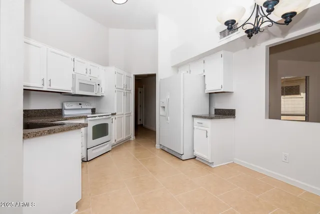 a kitchen with stainless steel appliances granite countertop white cabinets and a stove