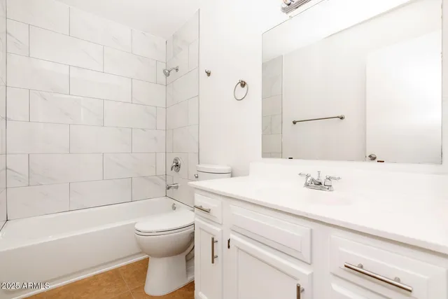 a bathroom with a sink double vanity granite tub shower and a mirror