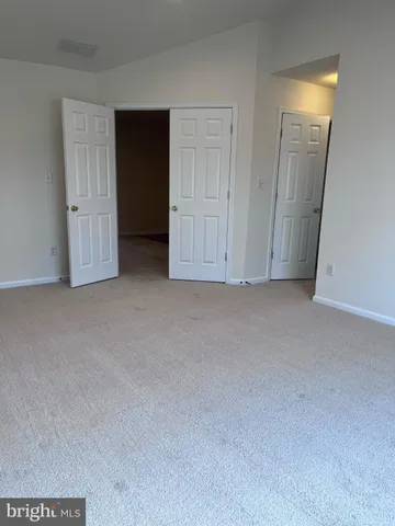 a view of an empty room and closet area