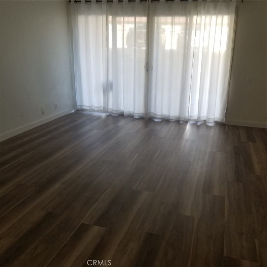 a view of wooden floor and window in an empty room