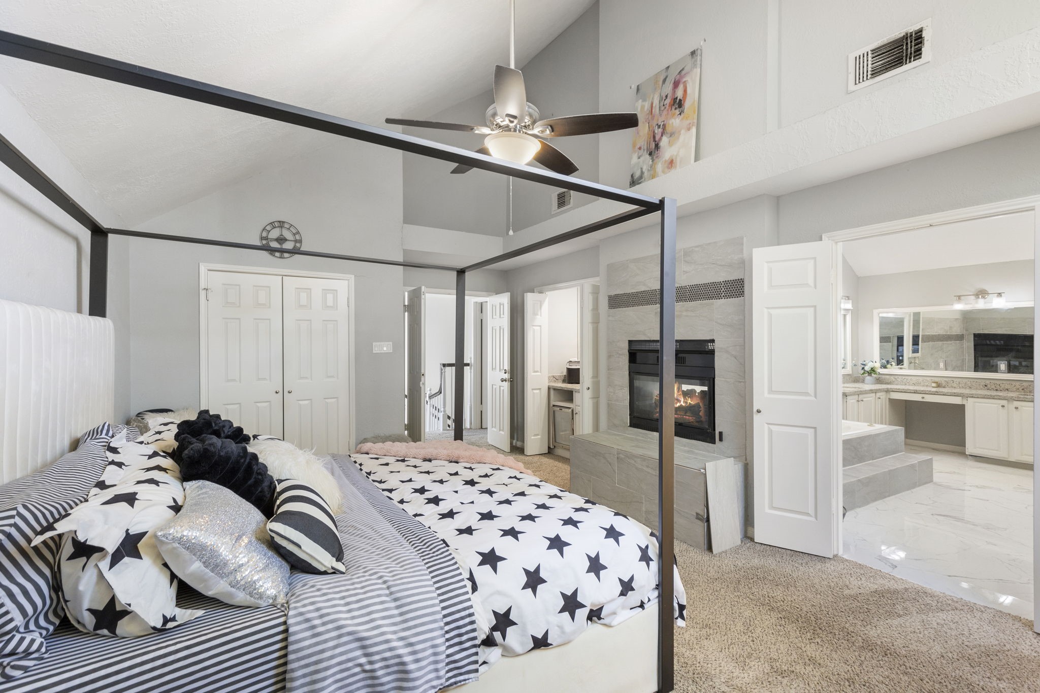 2110 Paso Rello Drive Houston, TX 77077 - Photo 26 of 41 This spacious primary bedroom features a cozy fireplace and vaulted ceiling. It connects to a luxurious ensuite bathroom with dual vanities, providing a perfect retreat.
