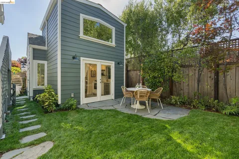 a view of a chair and table in backyard of the house