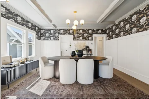 a dining room with wooden floor and white walls