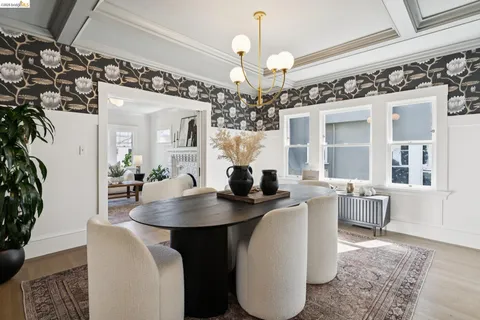 a dining room with wooden floor a chandelier a wooden table and chairs