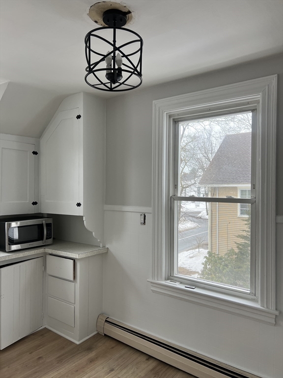 a kitchen with granite countertop stainless steel appliances white cabinets and a window