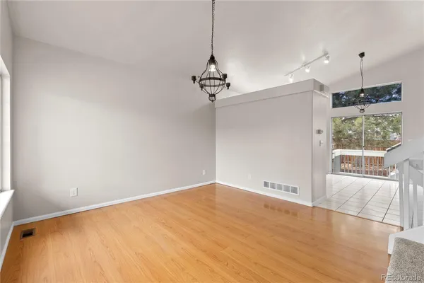 a view of a room with wooden floor and a ceiling fan