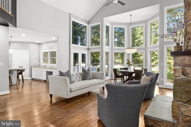 a large kitchen with stainless steel appliances granite countertop a stove a sink dishwasher a refrigerator and white cabinets with wooden floor