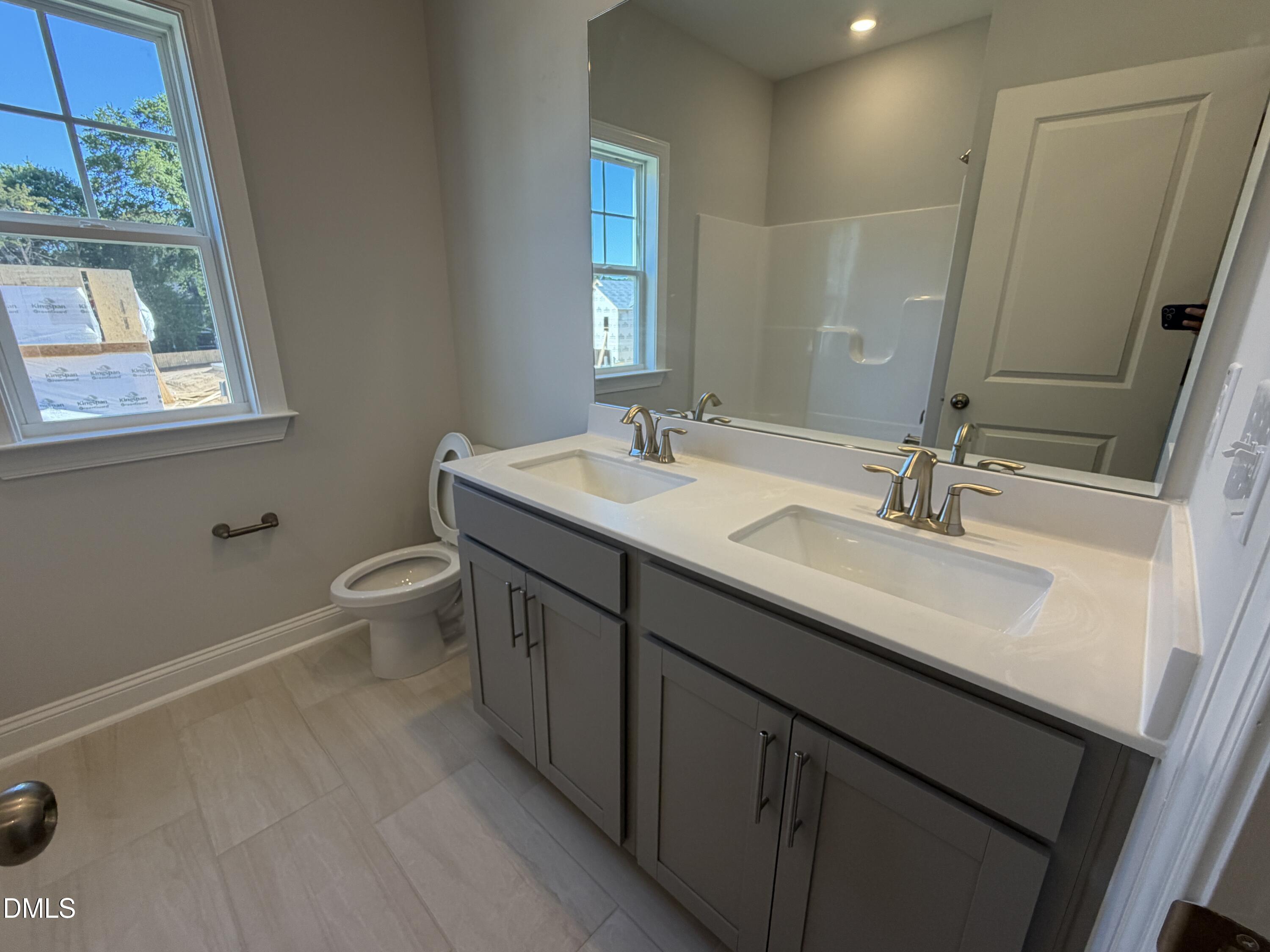 3016 Sandy Bluff Road Raleigh, NC 27616 - Photo 26 of 34 a bathroom with a double vanity sink a toilet and a mirror
