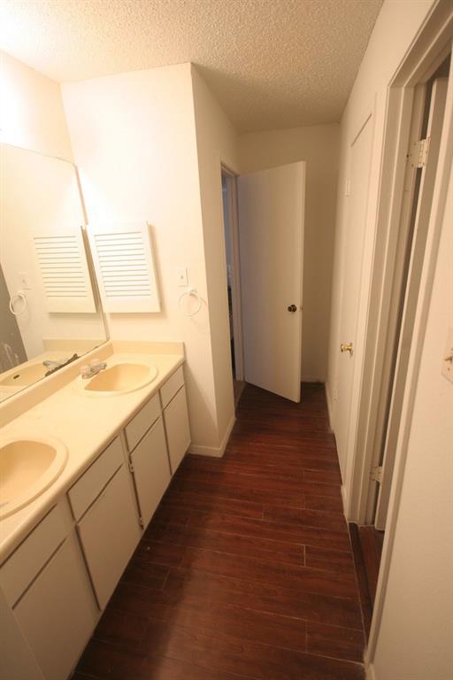 1906 West Loop, Unit D Austin, TX 78758 - Photo 4 of 5 Dual vanity with integrated sinks, white cabinetry, and wood-finish flooring