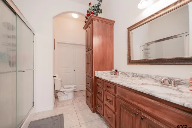a bedroom with a large bed and a chandelier