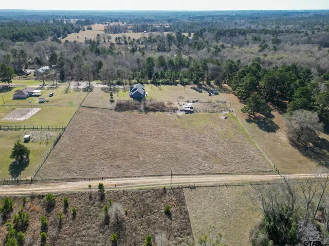 an aerial view of a house with a yard and lake view