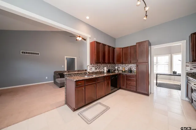 a kitchen with stainless steel appliances granite countertop a stove refrigerator and a sink